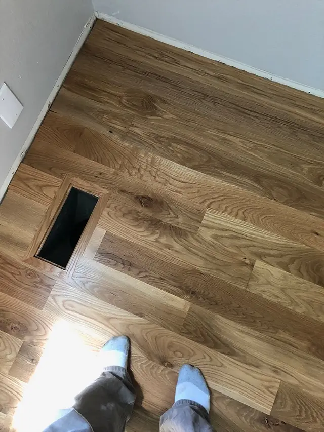 Oak plank floor beside a floor vent